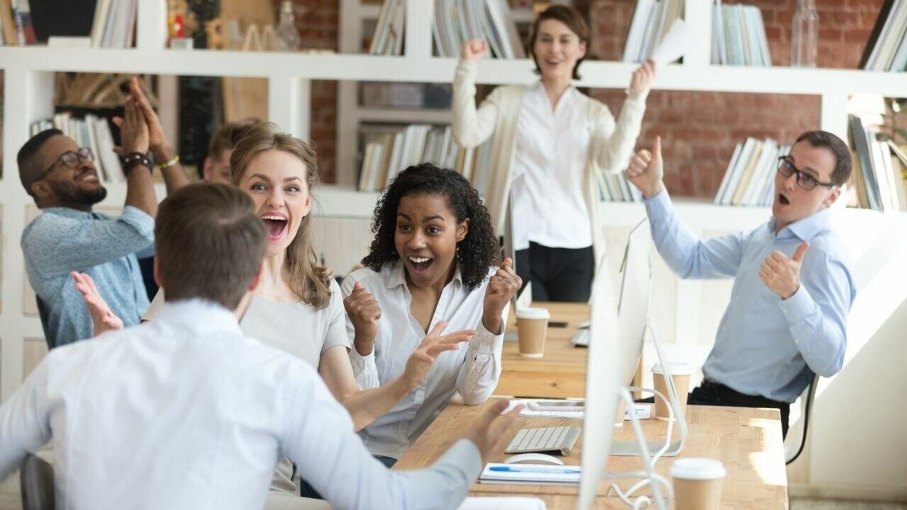 A team of people congratulating their colleague for a good job