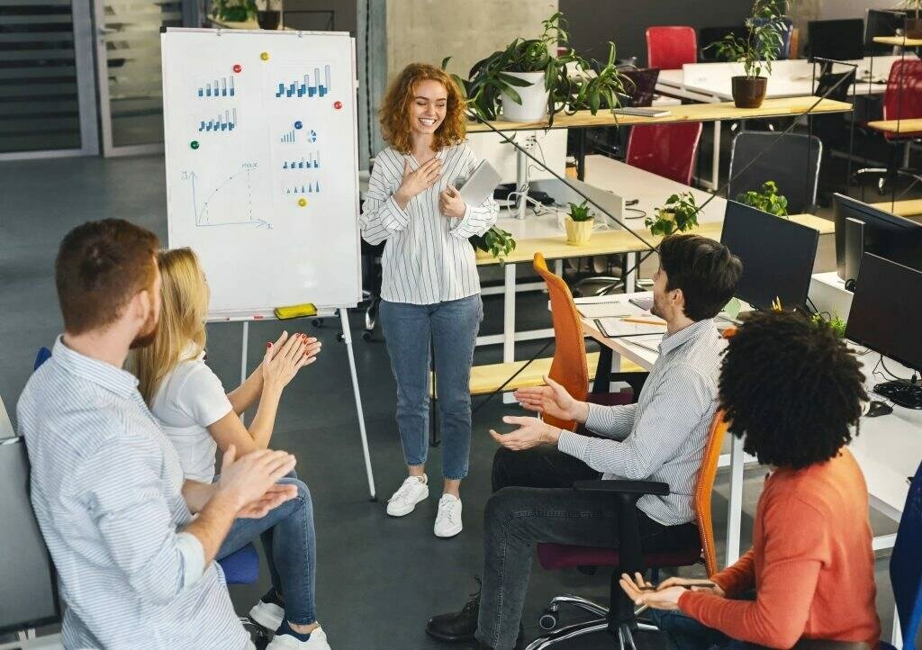 A woman presenting to her team inside the office